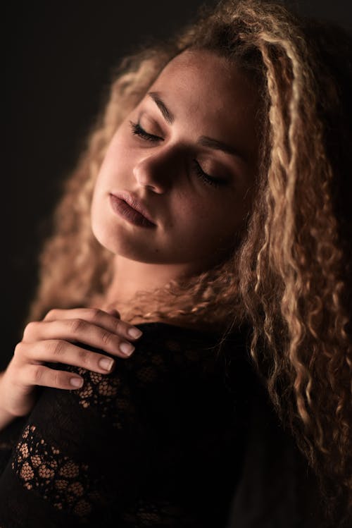 Free A woman with curly hair and black lace top Stock Photo