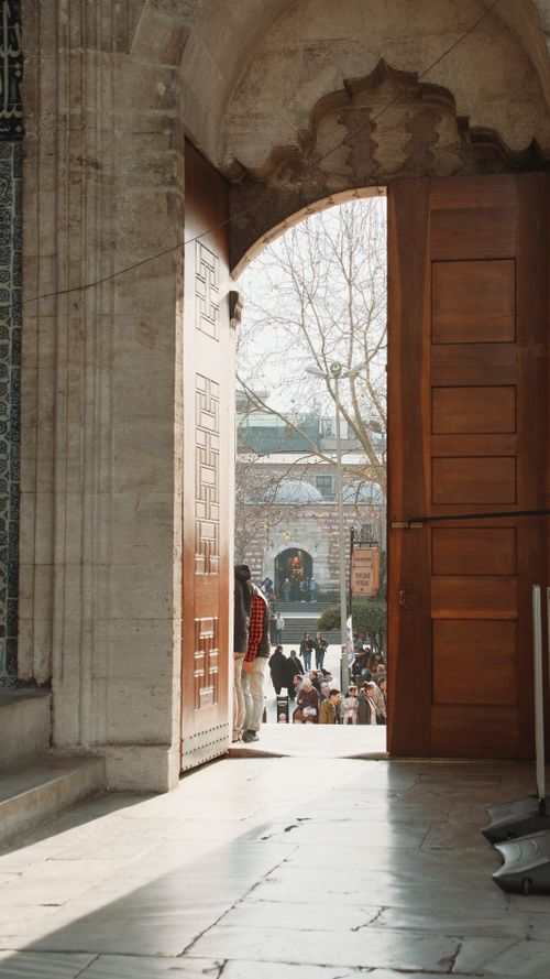 Free A captivating view from inside a historic mosque in Istanbul, Turkey, revealing a bustling scene outdoors. Stock Photo