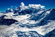 这张航拍照片令人惊叹，展现了白雪覆盖的山脉在清澈蓝天下的大自然之美