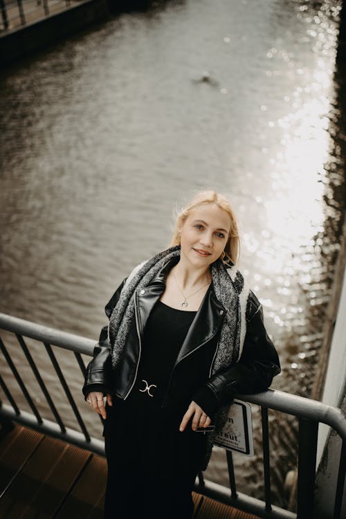 Blonde Woman Standing on Bridge by the Canal 