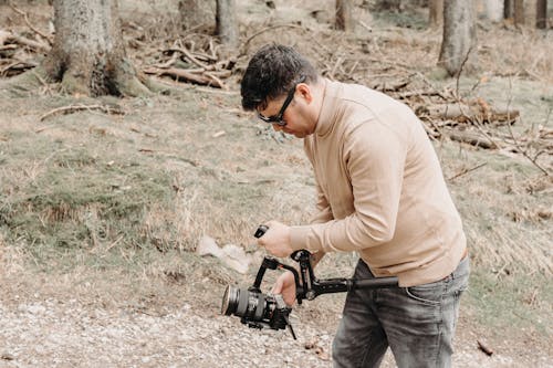 A man holding a camera in the woods