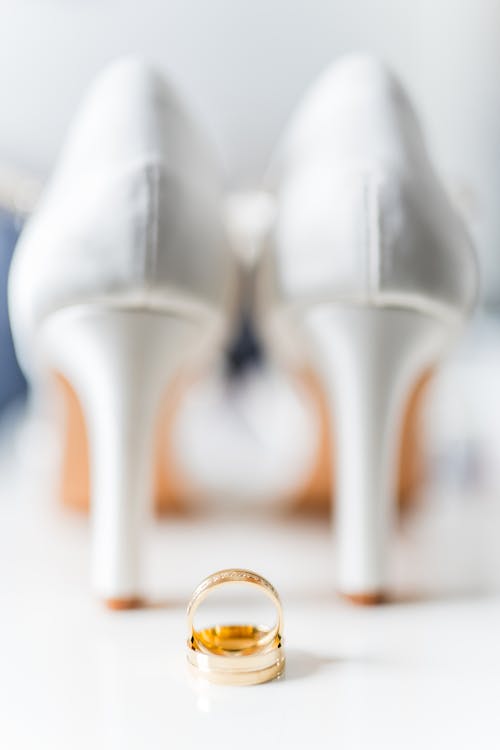 A wedding ring and shoes on a table