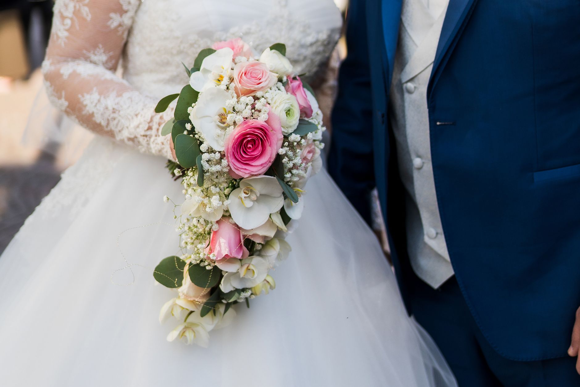 Bride and groom showcasing a beautiful floral bouquet during their wedding ceremony.