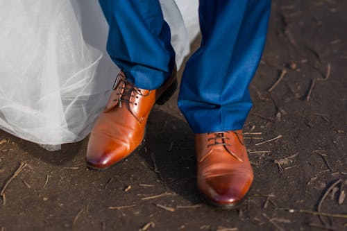A close up of a man's shoes and blue pants