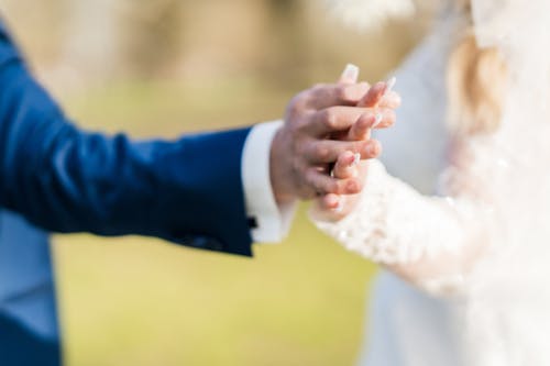 A bride and groom holding hands in a field
