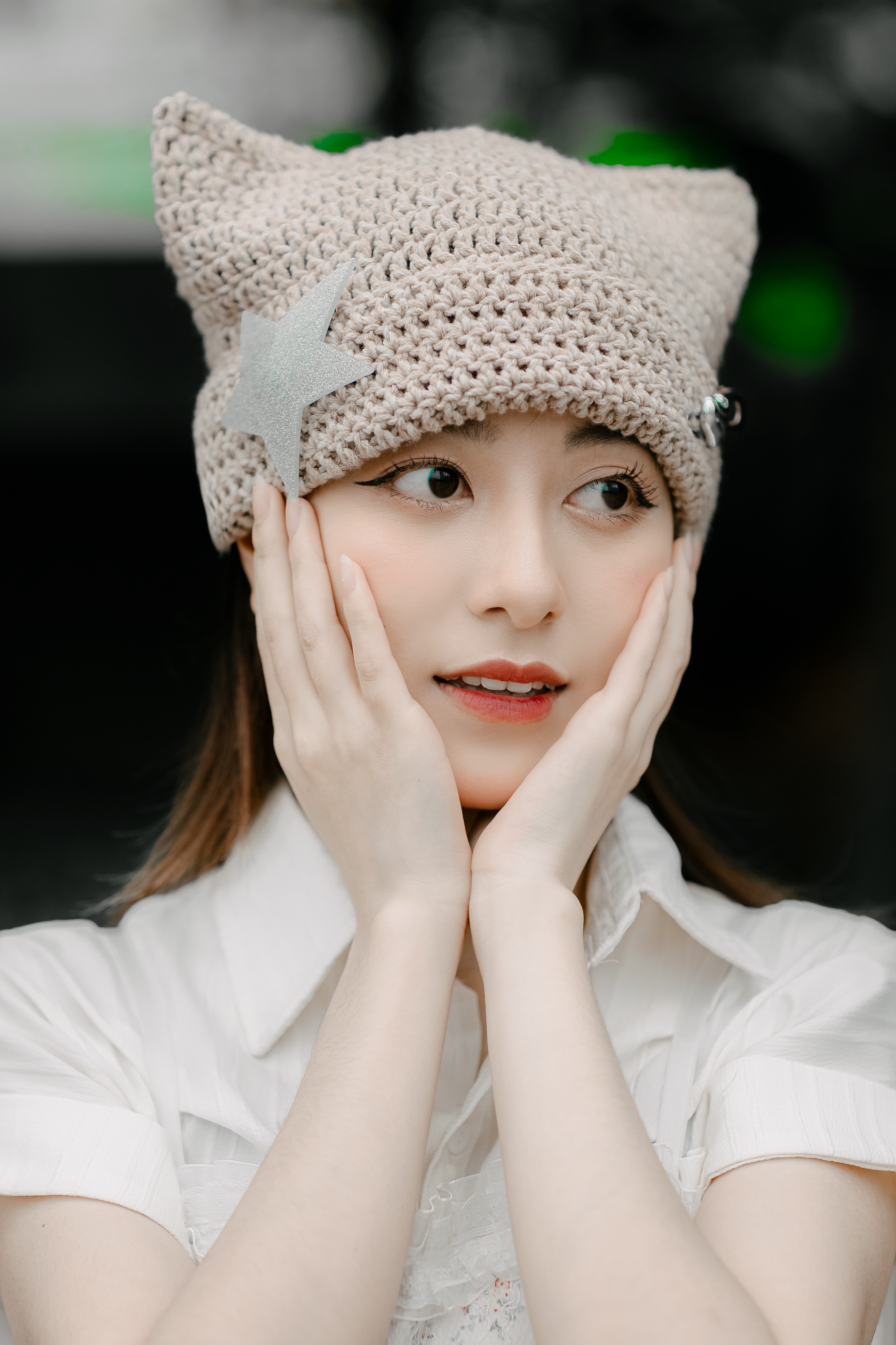 Chic portrait of an asian woman wearing a unique crochet hat with star detail.