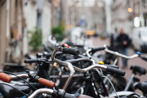 Free Detailed view of bicycle handlebars in a bustling urban street, embodying city life and transport. Stock Photo