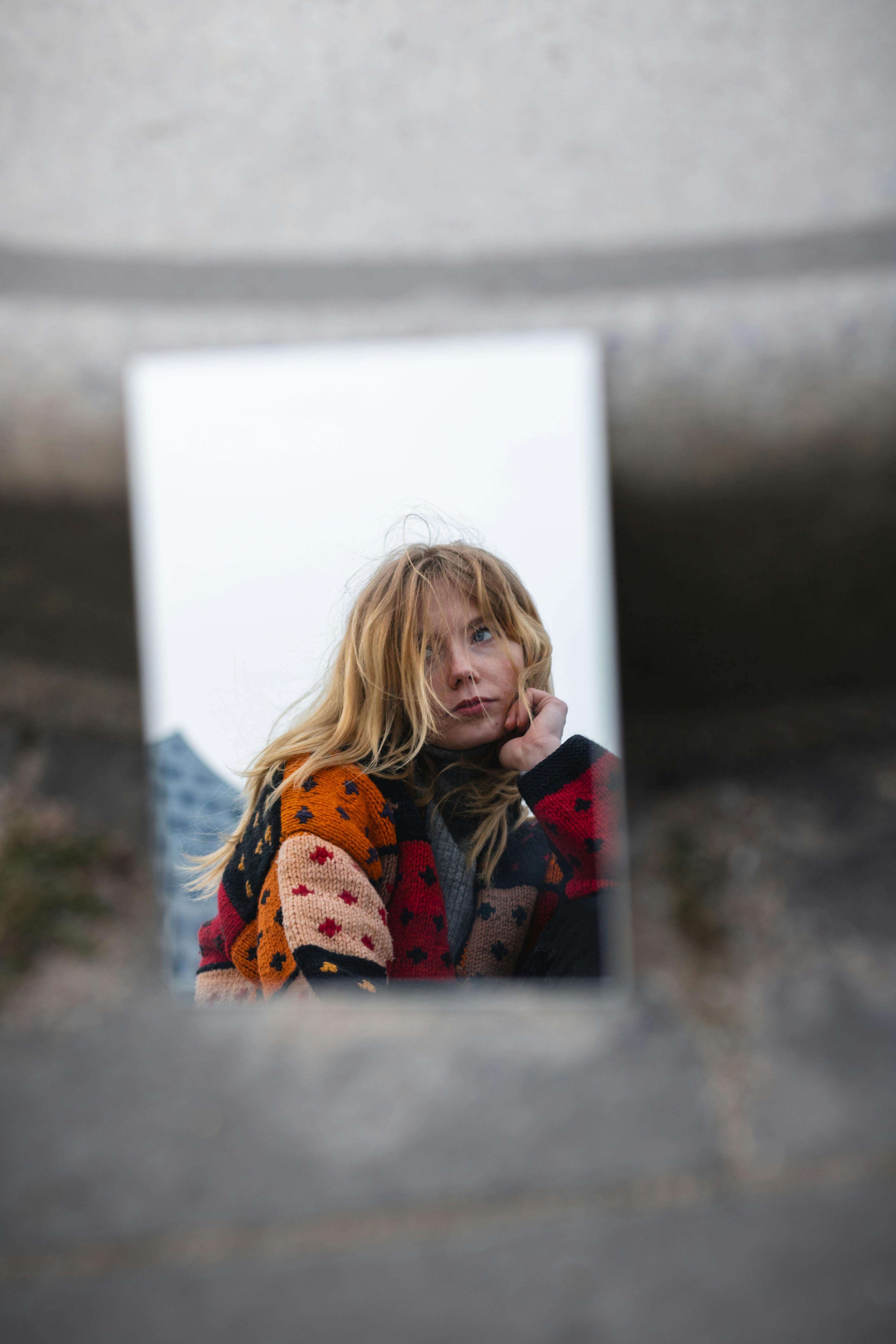 A woman is looking at herself in a mirror