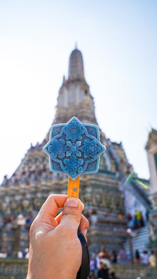 Woman Holding an Ice Cream in Front of Thai Temple