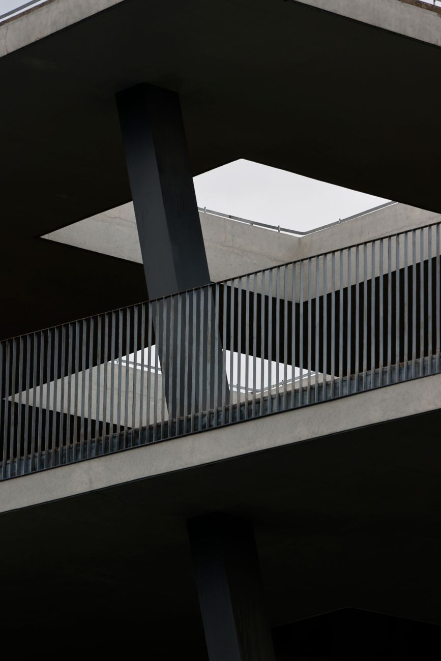 Abstract view of a modern building featuring geometric shapes and industrial railings.