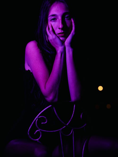 Young woman posing in pink lighting 