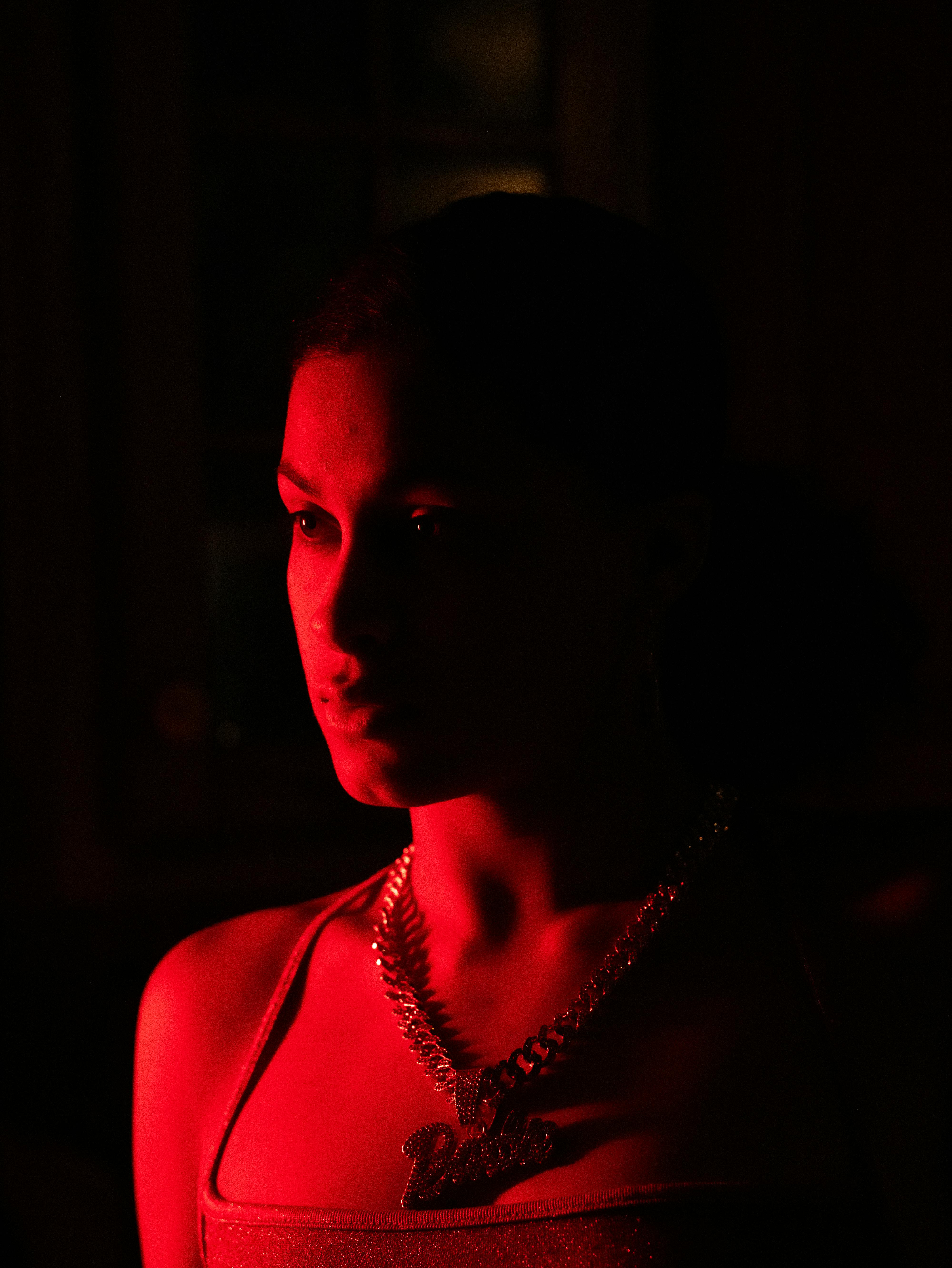 A striking cinematic portrait of a woman with dramatic red lighting creating a moody atmosphere.