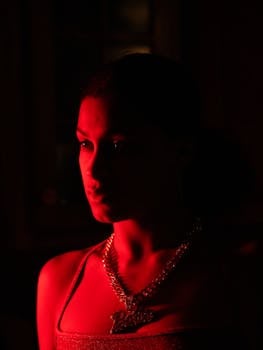A striking cinematic portrait of a woman with dramatic red lighting creating a moody atmosphere.