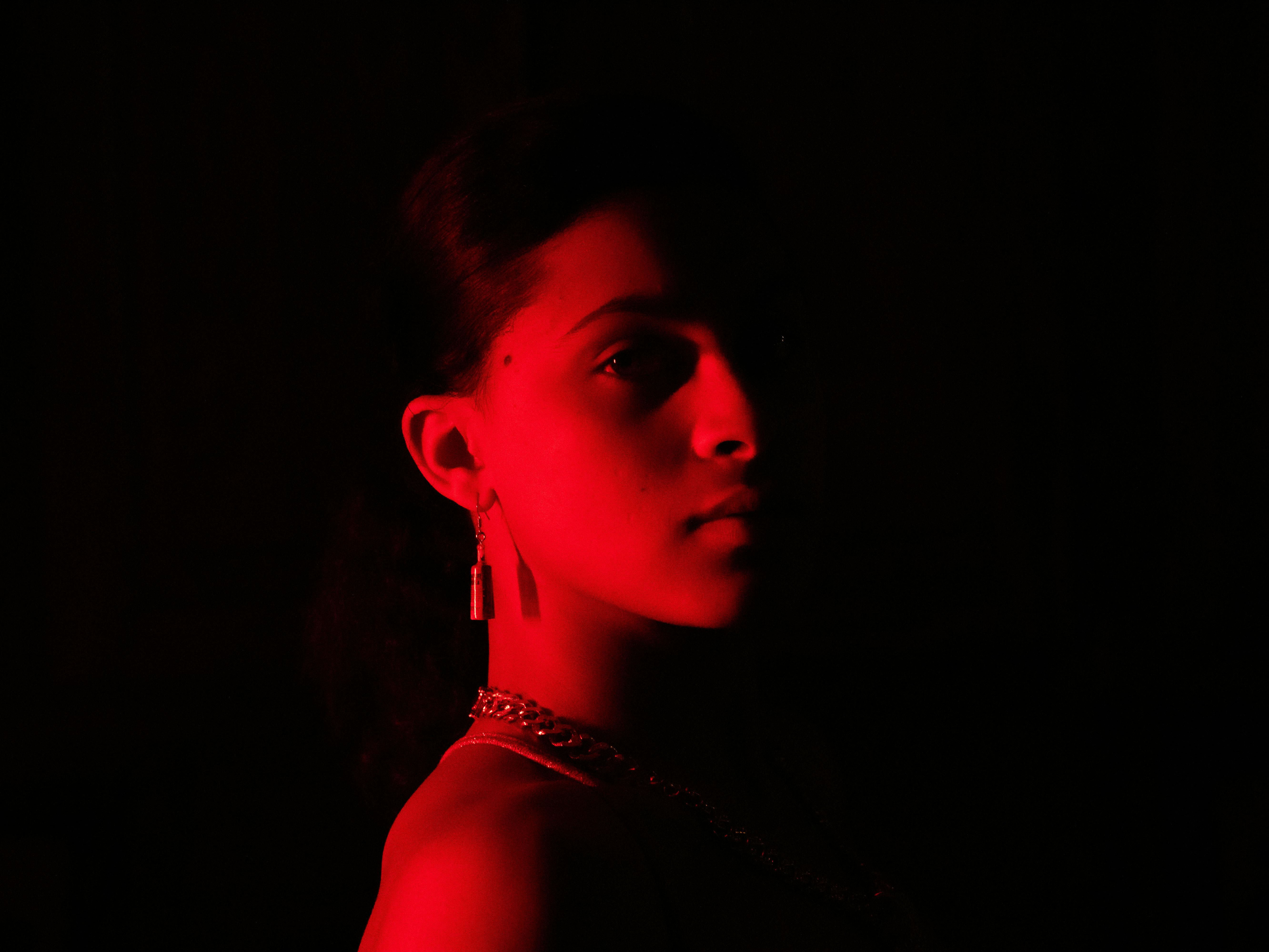 Striking portrait of a young woman illuminated by red light with a dramatic mood.