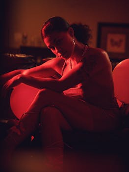 Cinematic portrait of a woman in red lighting, capturing mood and elegance in an indoor setting.