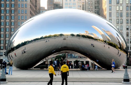 Two people standing in front of a large cloud gate