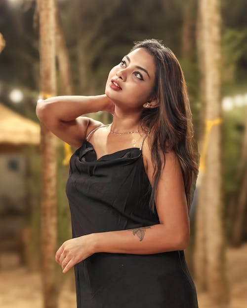Anusha in a black dress posing for the camera