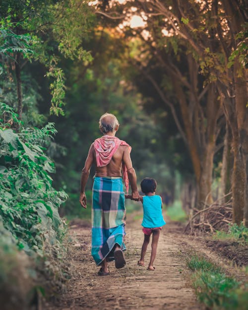 An old woman and child walking down a path