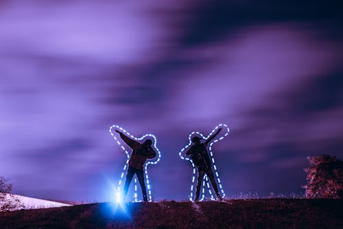 Two People Standing on Hill at Night Time