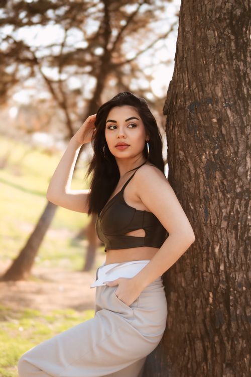 Free Stylish portrait of a woman in a park, showcasing chic fashion and natural beauty. Stock Photo