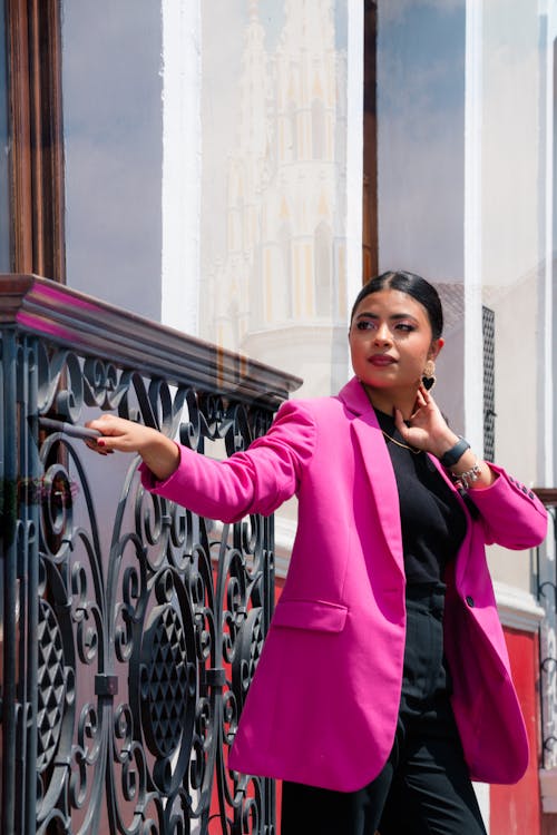 A woman in a pink blazer and black pants