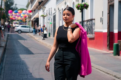 Brunette Woman Standing with Pink Suit Jacket on Street