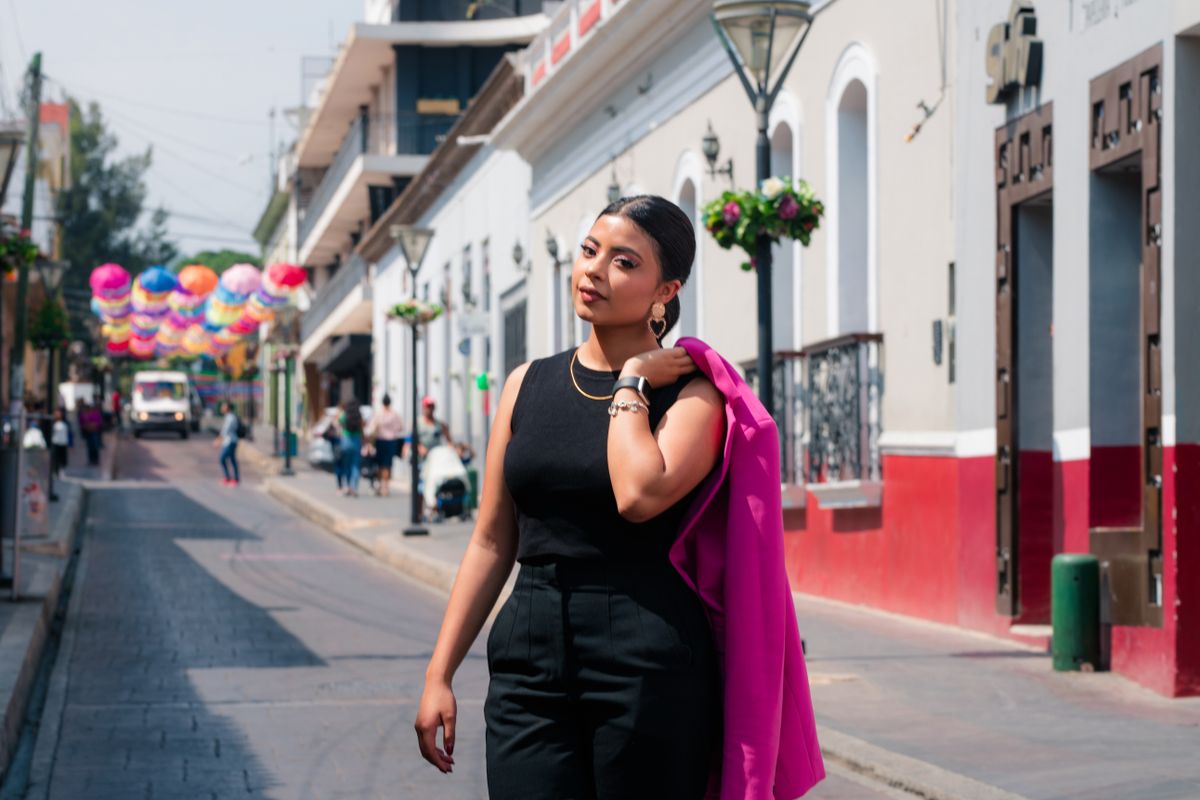Latina woman wearing a bold red statement dress with confidence