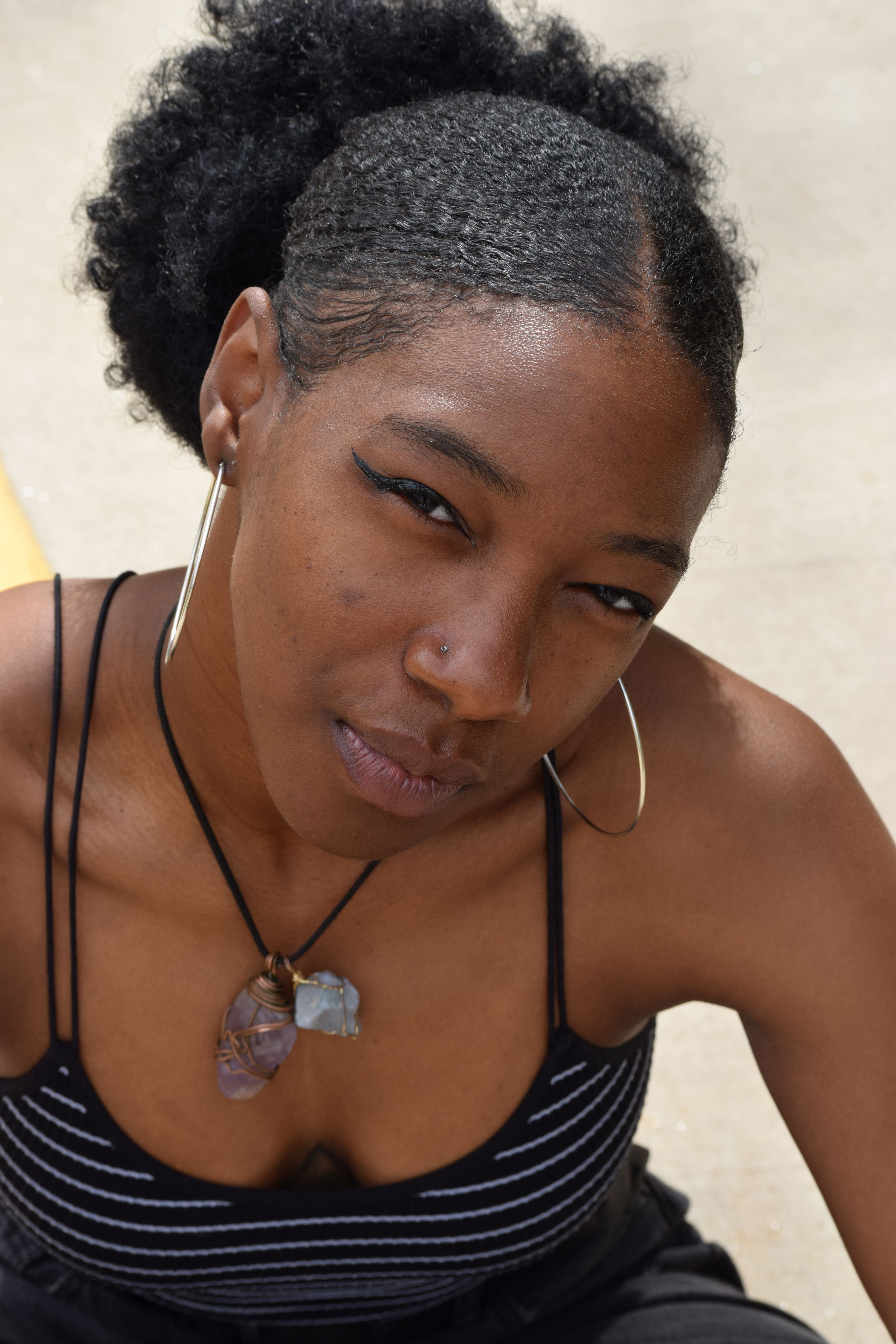 Stylish outdoor portrait of a woman with earrings and necklace in Alpharetta, Georgia.