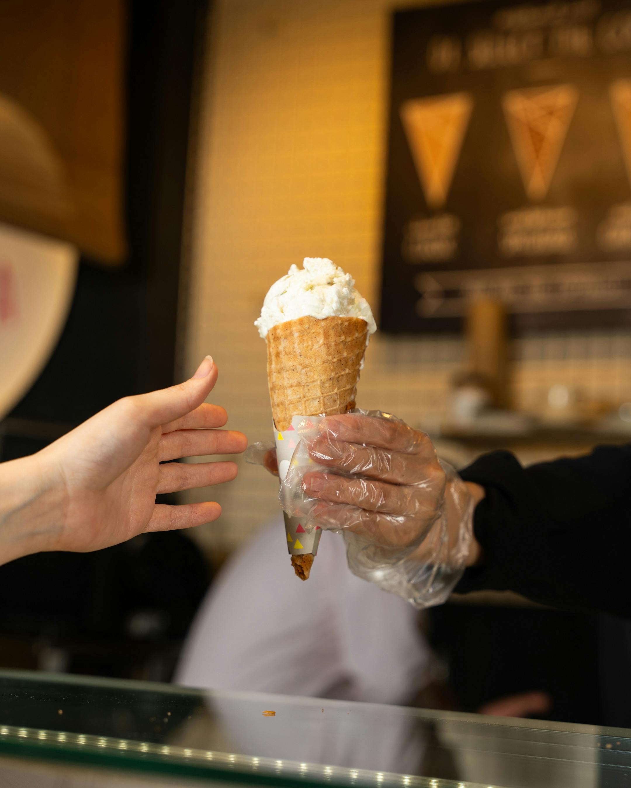 Hands Holding Ice Cream in Cafe