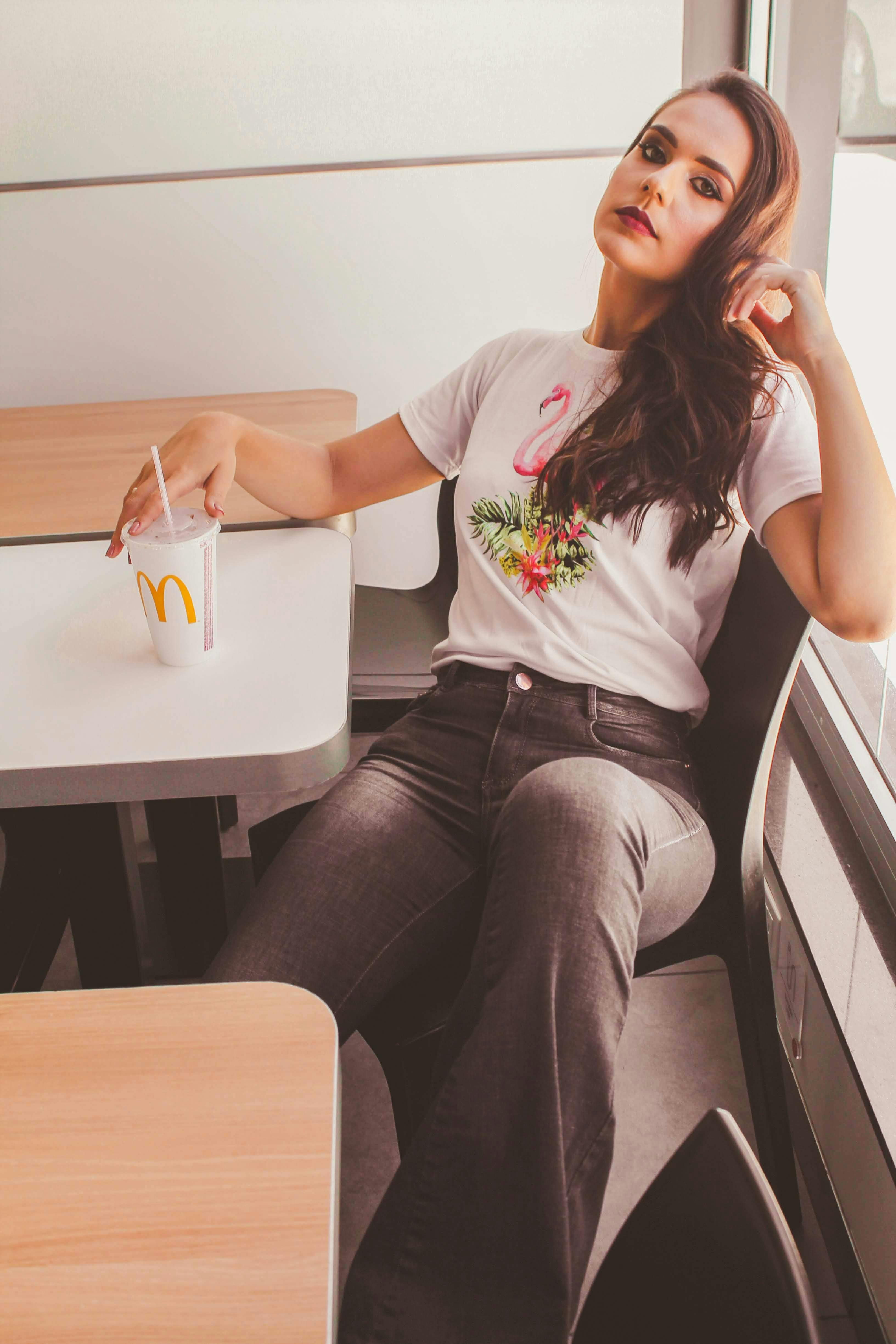 woman sitting down holding mcdonald s cup