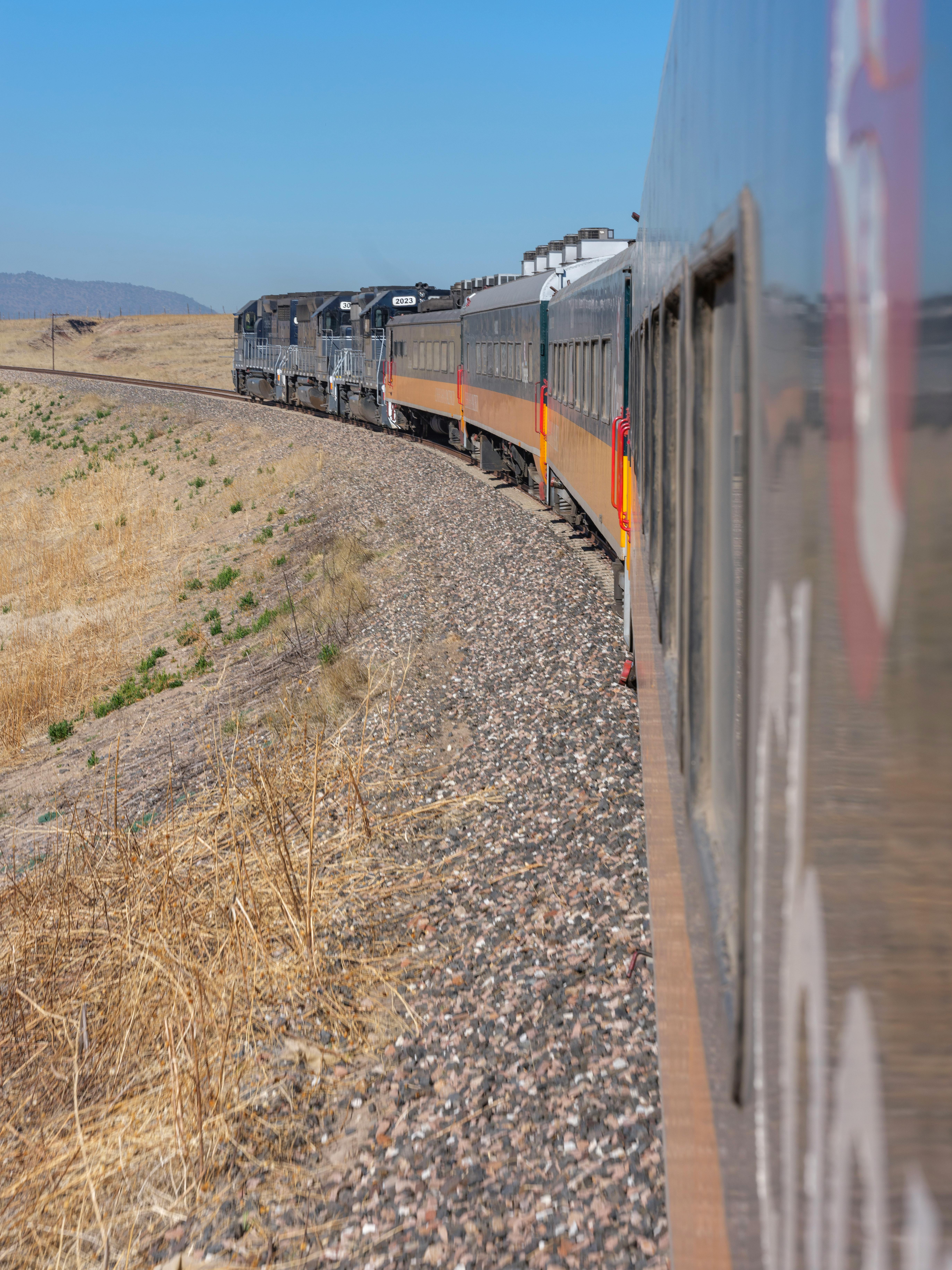 Free A picturesque train ride through Chihuahua, capturing the vast landscape and railway tracks. Stock Photo