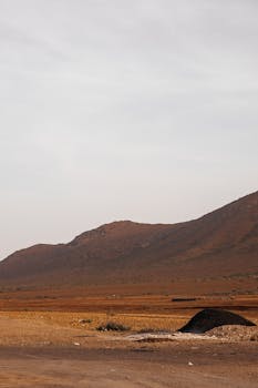 Tranquil rural scene featuring rolling hills under a vast and clear sky.