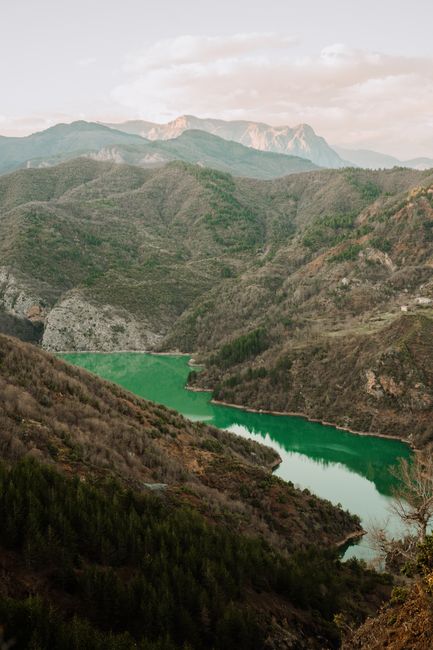 Stunning birds eye view of Pukë's vibrant landscape and green lake in Albania.