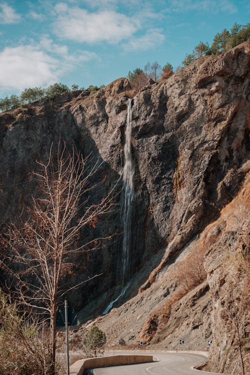 A road with a waterfall in the background