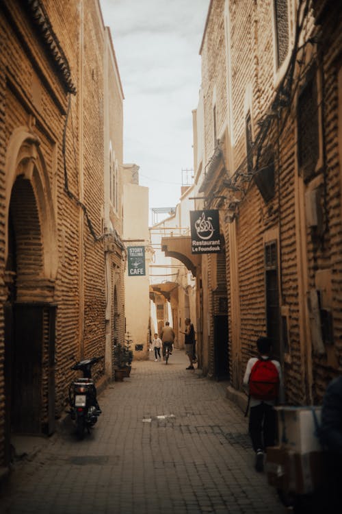 A narrow alley with people walking down it