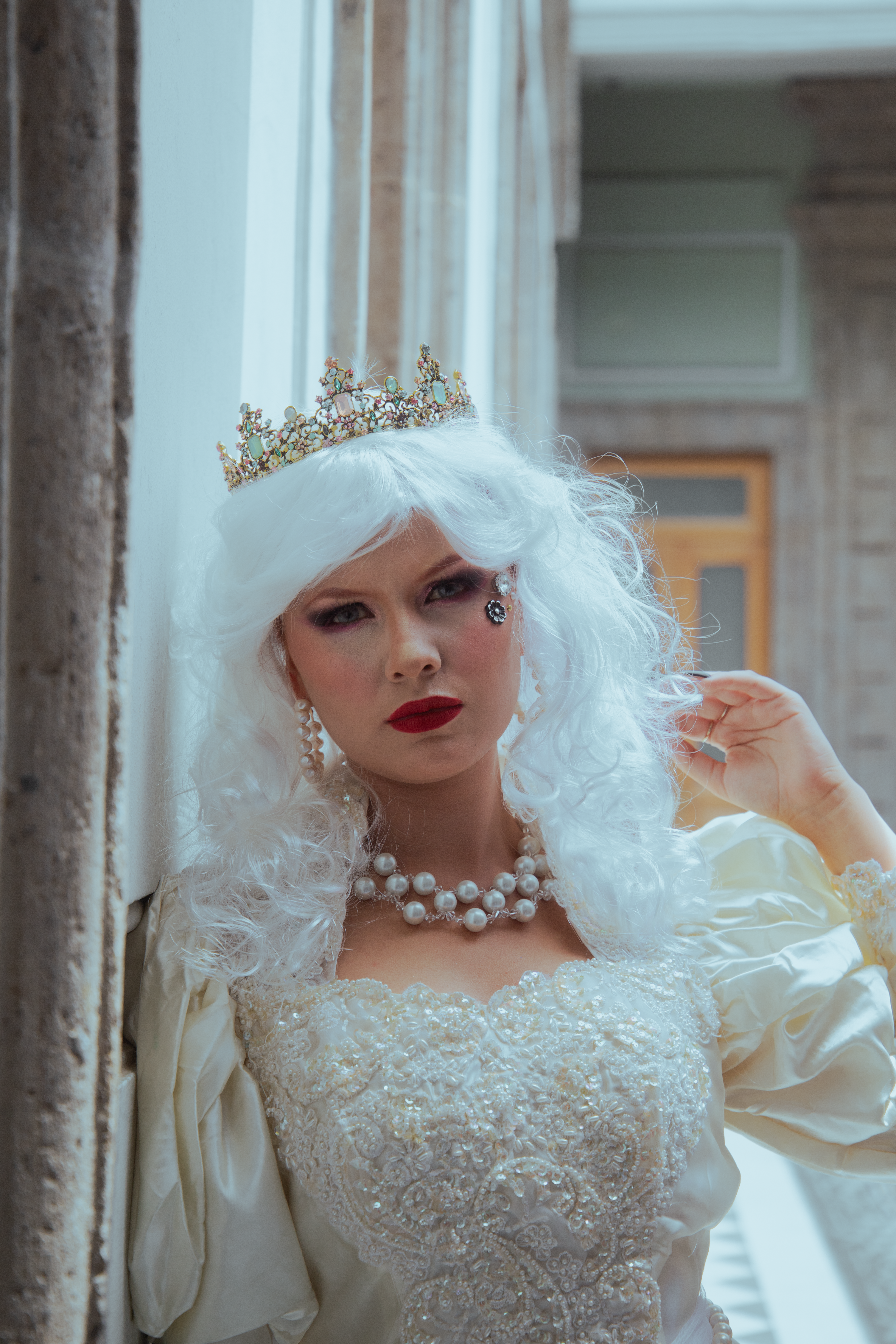 A portrait of a woman in vintage bridal attire with a tiara, captured indoors in Mexico City.