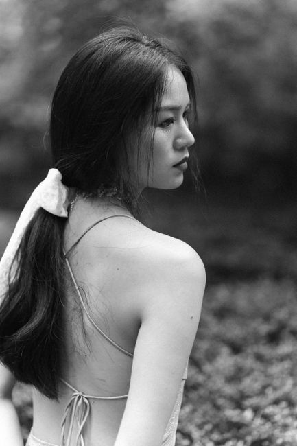 Black and white portrait of a woman in a backless dress, exuding elegance and grace.