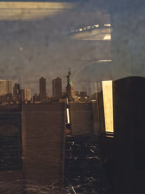 A reflection of the statue of liberty in a window