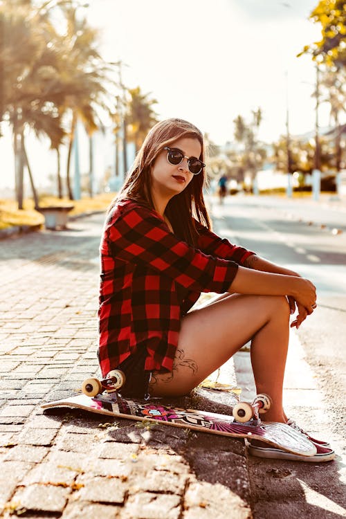 Free Woman Sitting Beside Skateboard Stock Photo