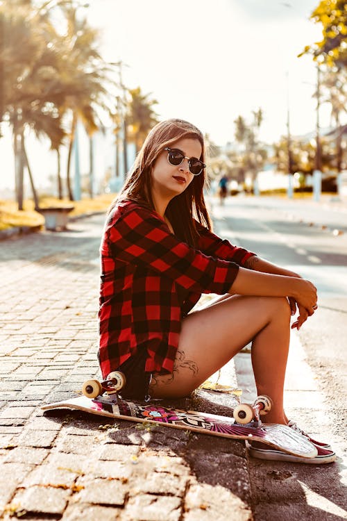 Frau Sitzt Neben Skateboard