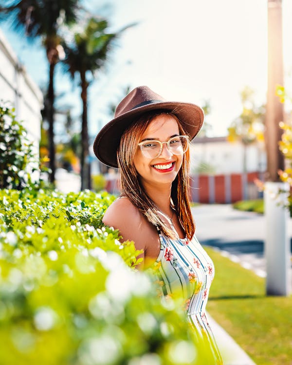 Smiling Woman Wearing White-and-blue Striped Floral Tank Top and Black Hat