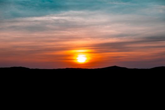 Gorgeous sunset with vibrant colors and silhouetted hills, perfect for nature enthusiasts.