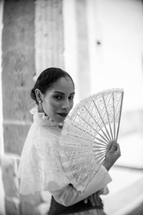A woman in a traditional dress holding a fan