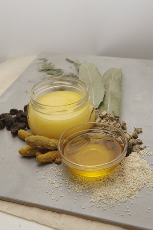 A jar of oil and herbs on a cutting board