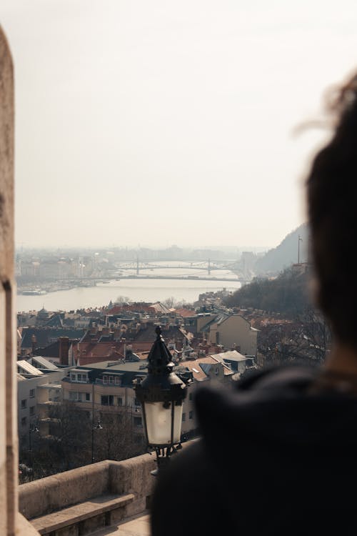 A person looking out over a city with a river