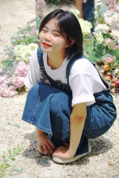 Girl Squatting in Overalls