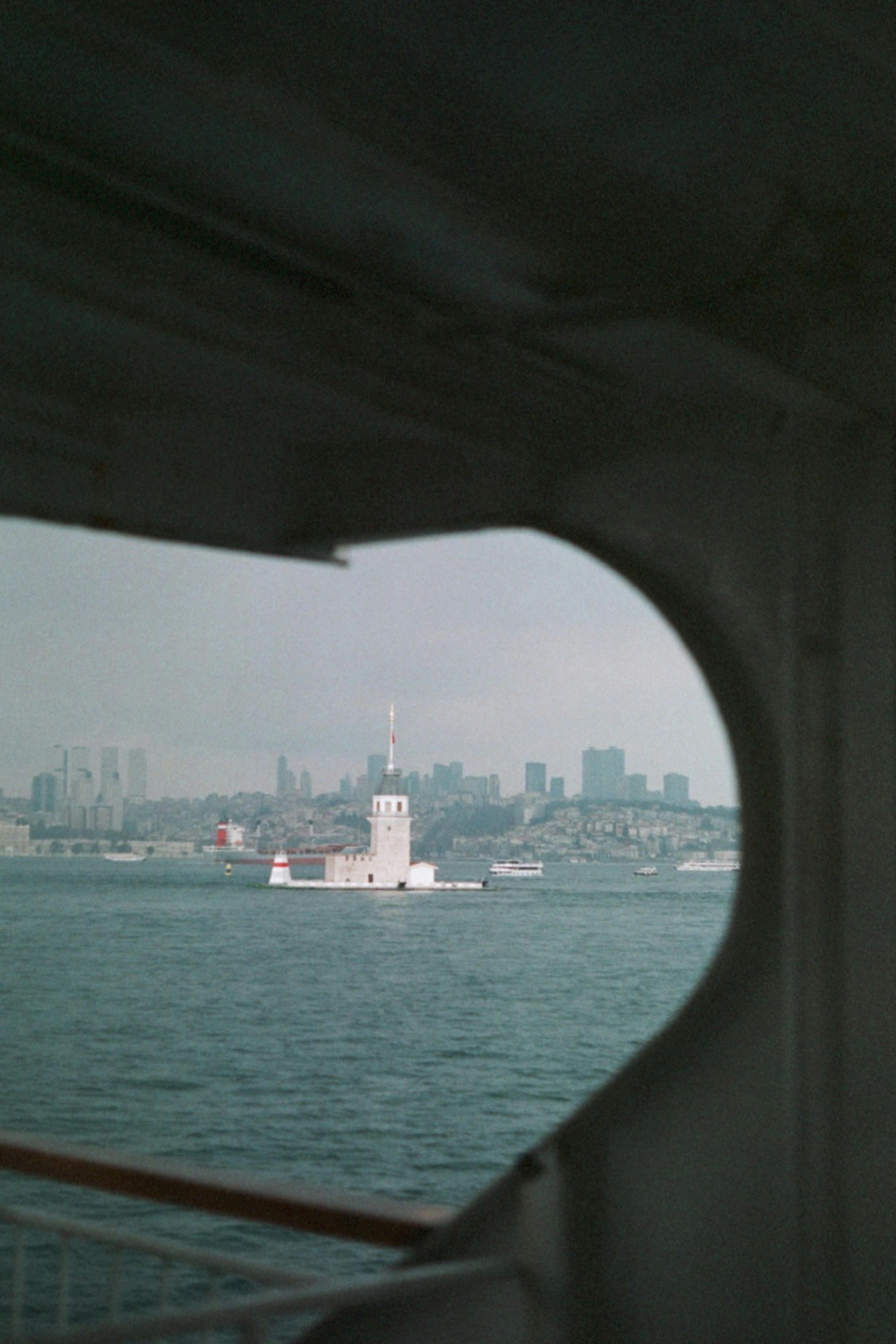 Captivating view of Istanbul's Maiden's Tower framed by a ferry window, highlighting Turkey's iconic landmark.