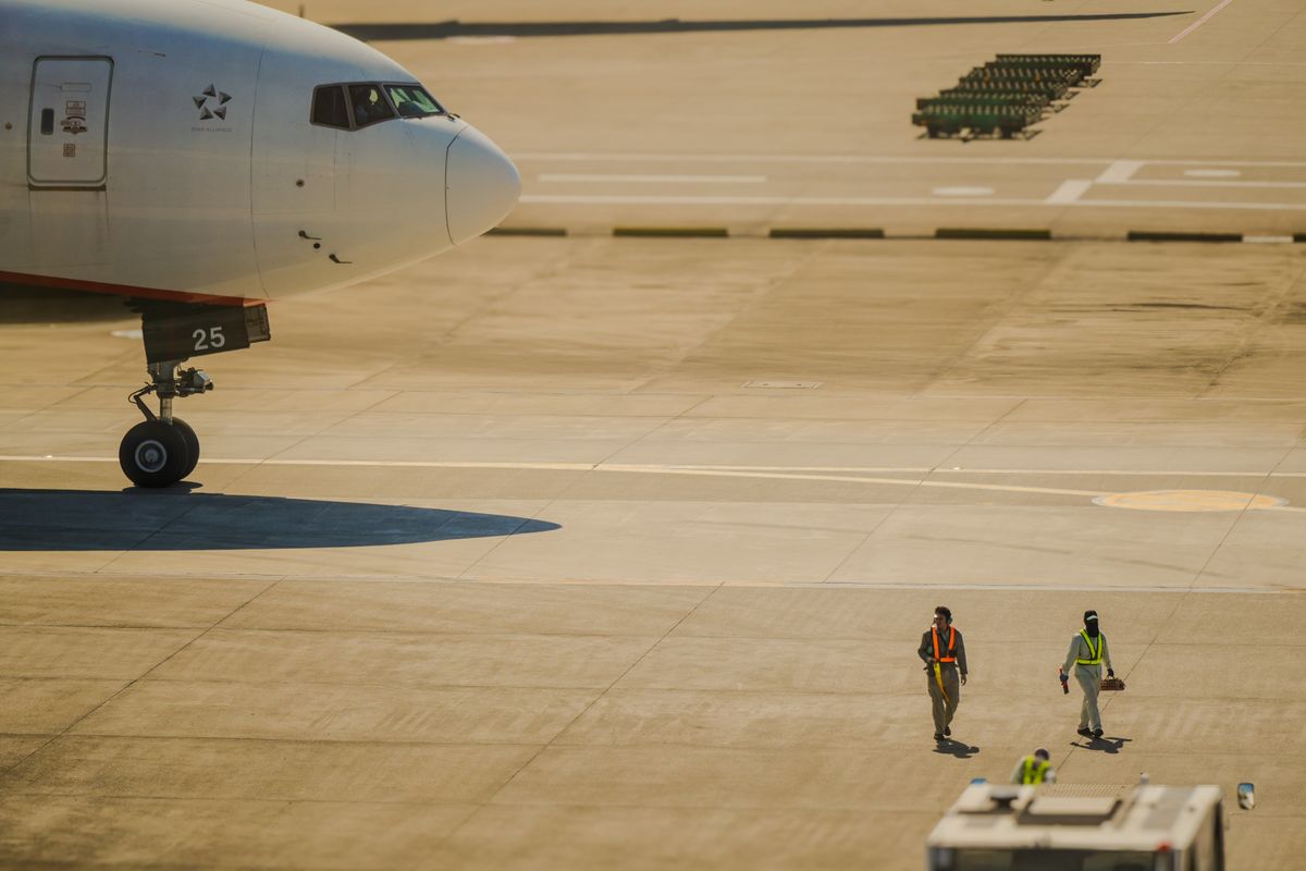 Airline crew walking on the tarmac beside an aircraft