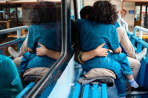 A couple sitting on a bus with their backs to each other