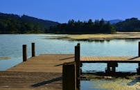 在宁静的夏日湖中，木制码头通向平静的水域，让人体验一份宁静